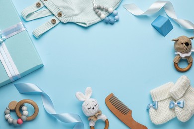 Photo of Frame of baby clothes and accessories on turquoise background, flat lay. Space for text