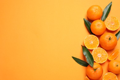 Flat lay composition with fresh ripe tangerines and space for text on orange background. Citrus fruit
