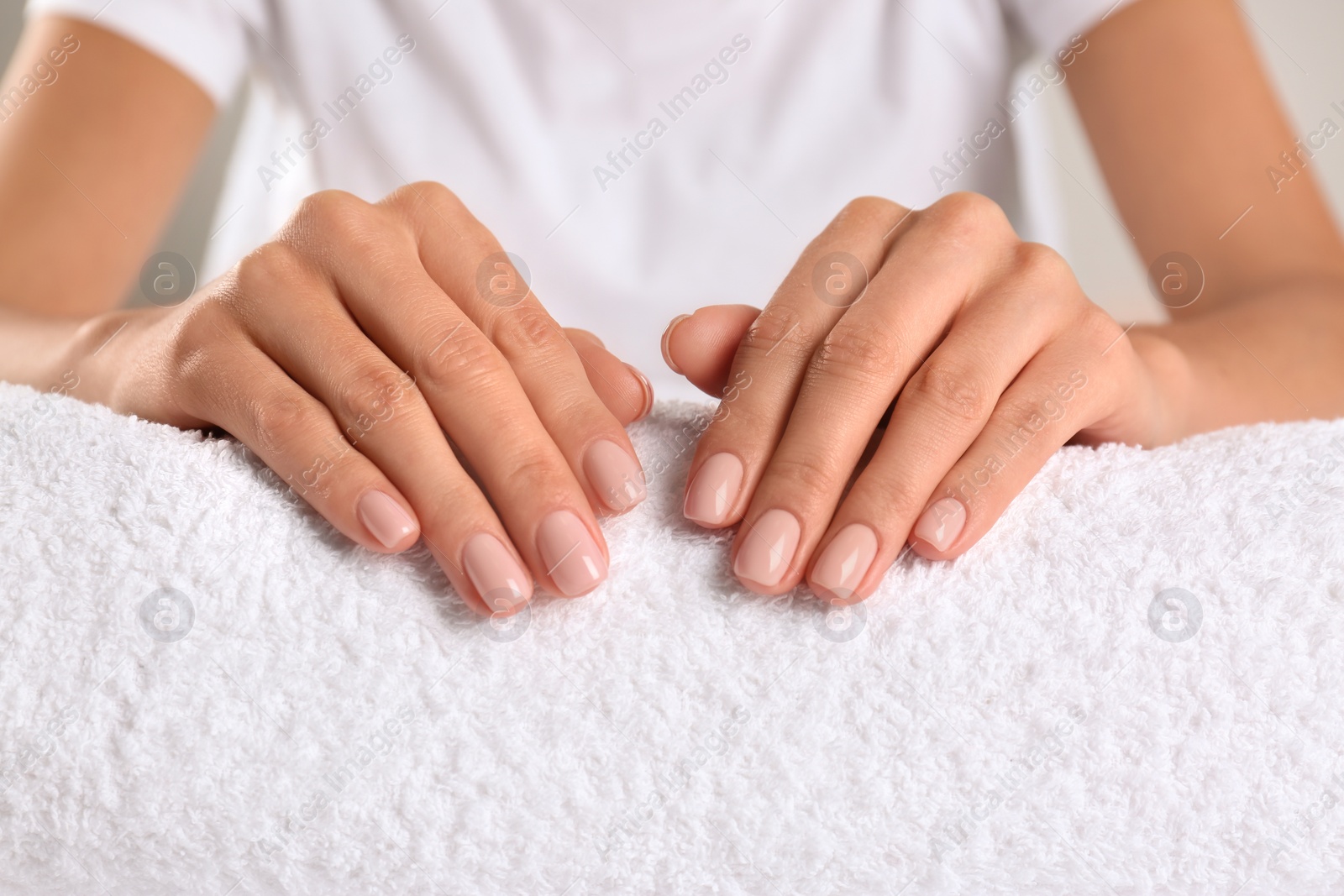 Photo of Closeup view of beautiful female hands on towel. Spa treatment