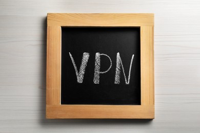 Chalkboard with acronym VPN on wooden table, top view