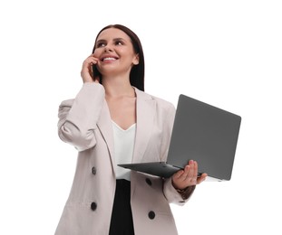 Beautiful businesswoman in suit with laptop talking on smartphone against white background, low angle view