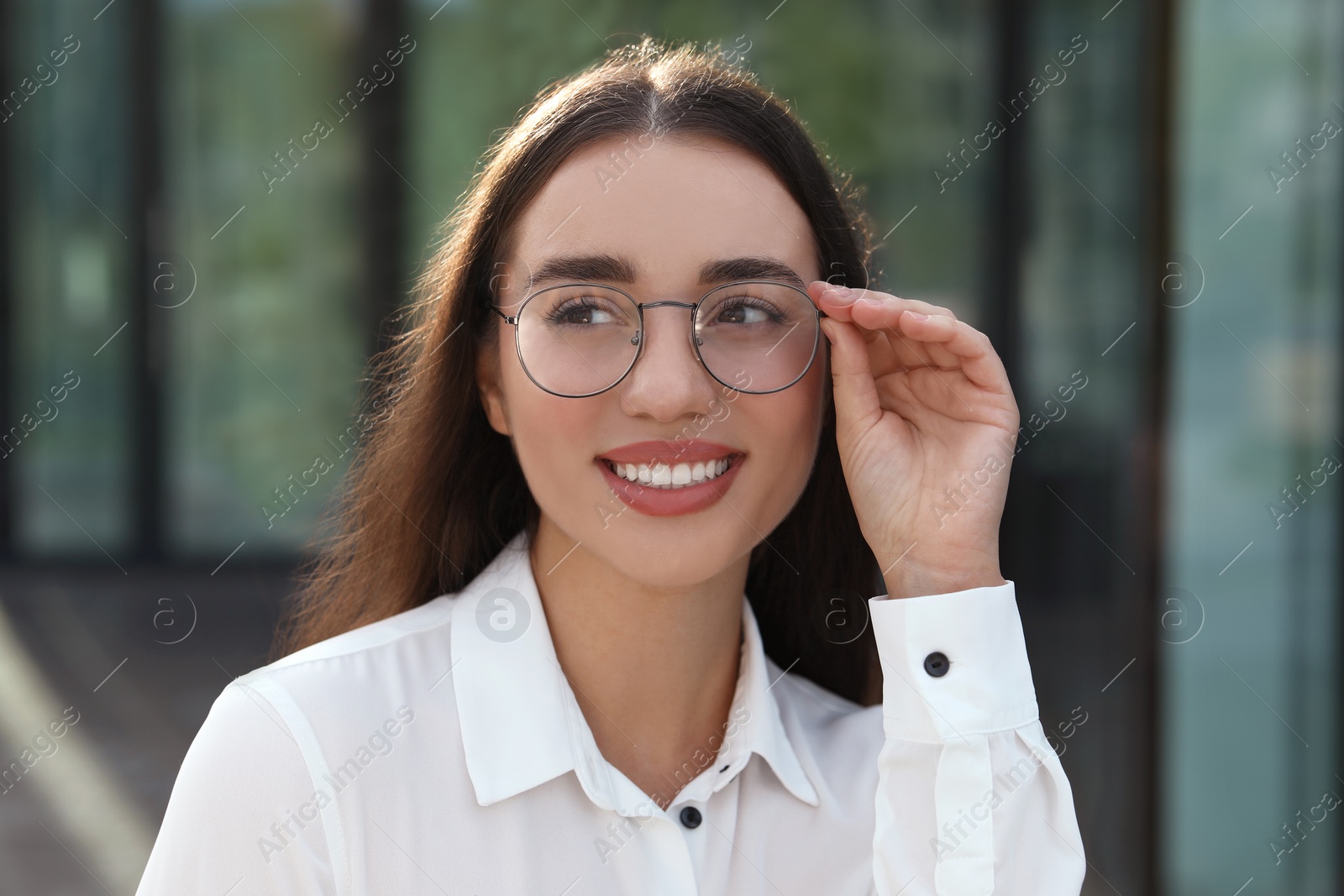 Photo of Portrait of beautiful woman in glasses outdoors. Attractive lady smiling and posing for camera