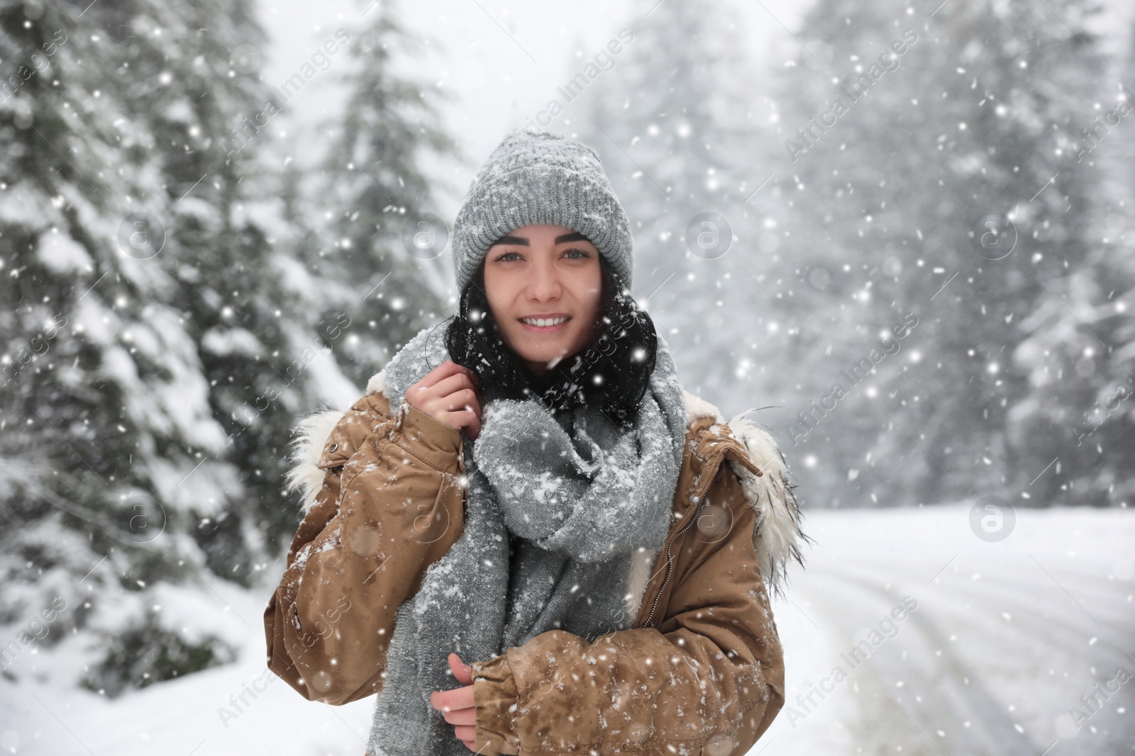 Photo of Young woman wearing warm clothes outdoors on snowy day. Winter vacation