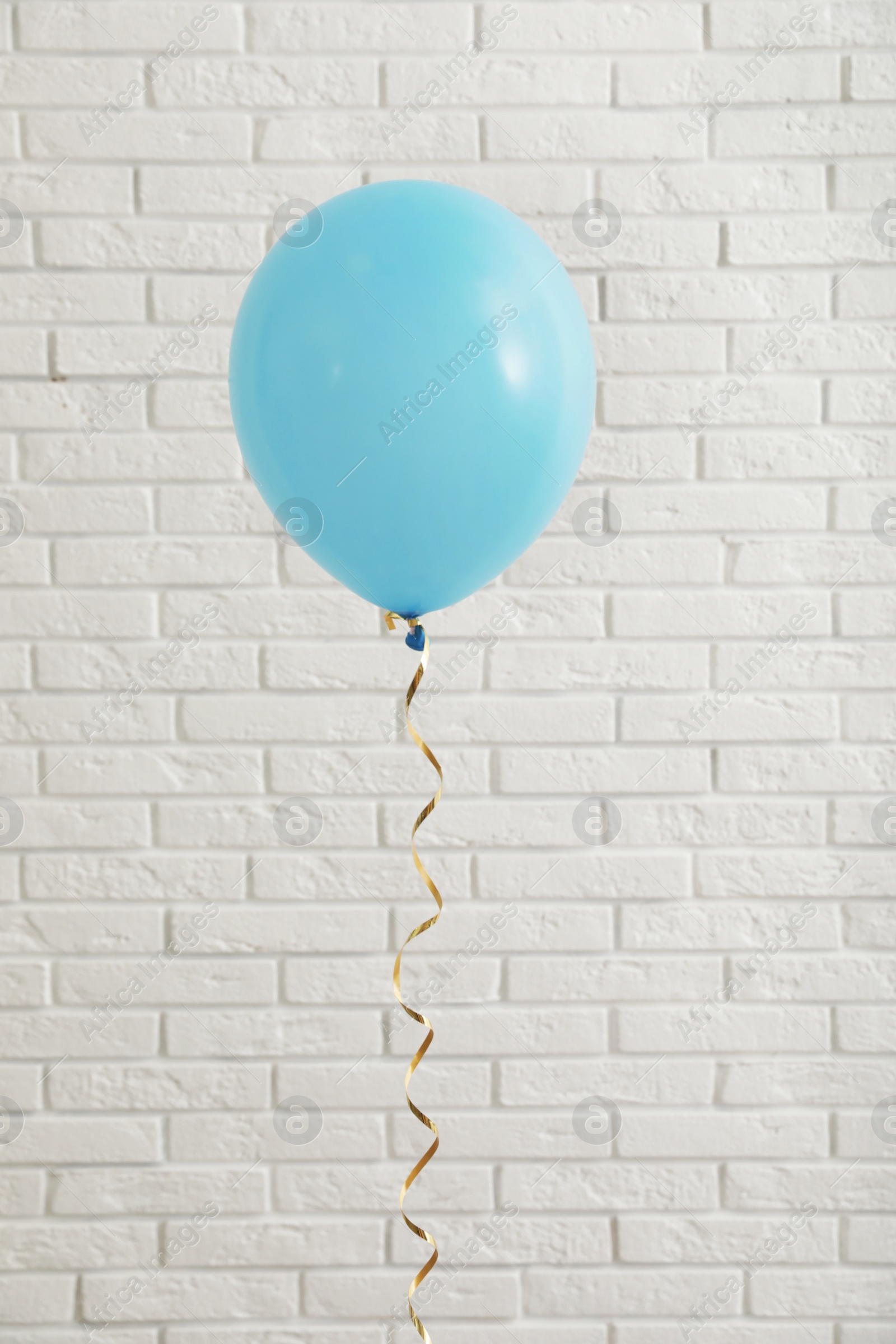 Photo of Bright balloon near brick wall. Celebration time