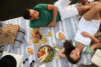 Happy couple spending time on pier at picnic, above view