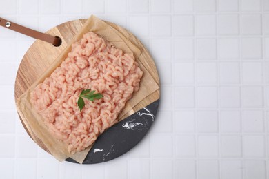 Photo of Fresh raw minced meat on white tiled table, top view. Space for text