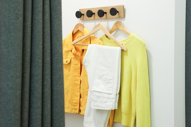 Photo of Stylish women's clothes on rack in dressing room