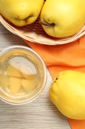 Delicious quince drink in glass and fresh fruits on wooden table, top view