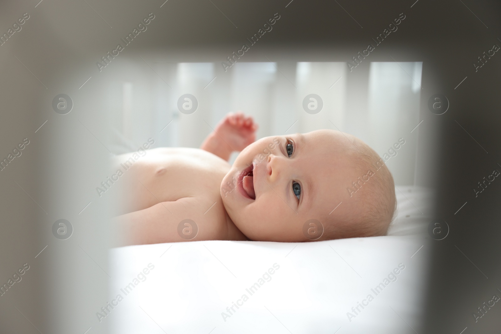 Photo of Cute little baby lying in crib at home