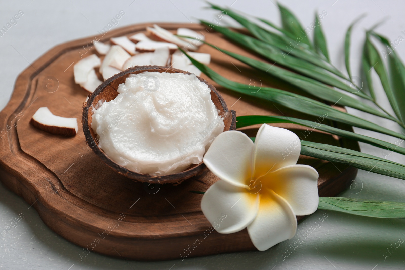 Photo of Beautiful composition with coconut oil on wooden board