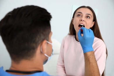 Doctor taking sample for DNA test from woman in clinic