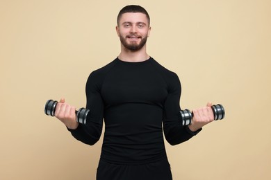 Handsome sportsman exercising with dumbbells on brown background