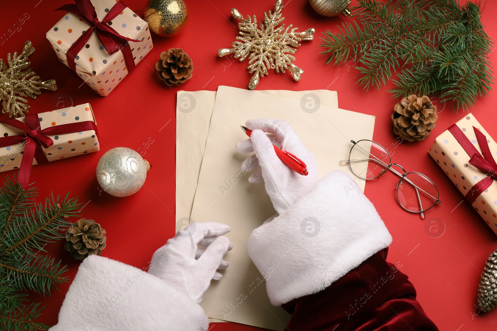 Photo of Top view of Santa writing letter at red table, closeup