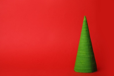 Photo of Christmas tree made of green ribbon on red background, space for text