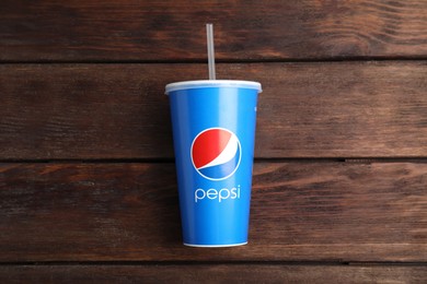 MYKOLAIV, UKRAINE - JUNE 08, 2021: Paper Pepsi cup on wooden background, top view