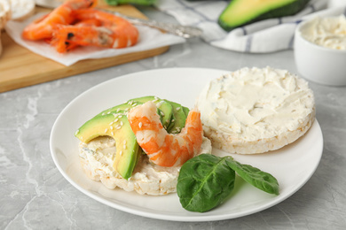 Photo of Puffed rice cake with shrimp and avocado on grey marble table