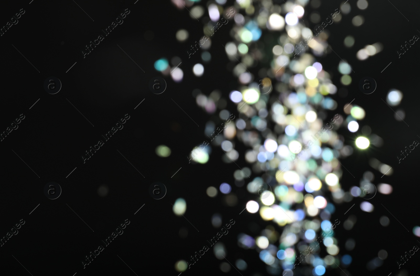 Photo of Blurred view of colorful festive lights on black background. Bokeh effect