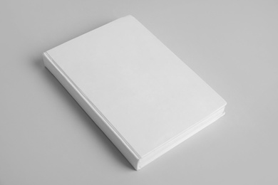 Book with blank cover on grey background