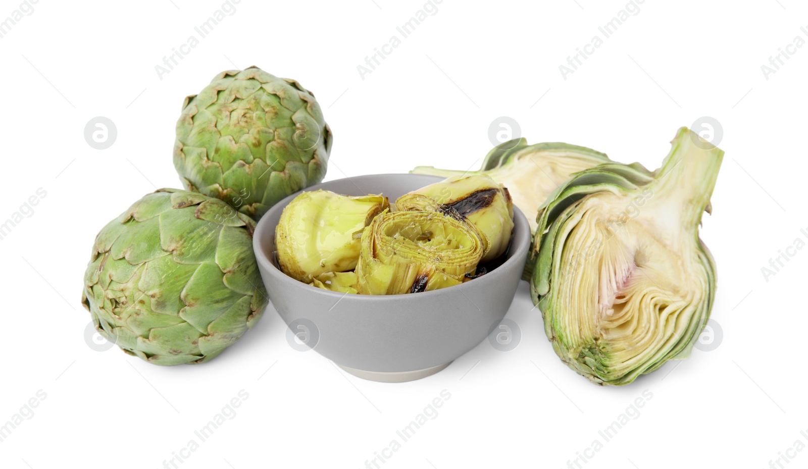 Photo of Bowl with delicious pickled artichokes and fresh vegetables on white background