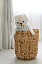 Funny toy dog in basket on floor. Decor for children's room interior