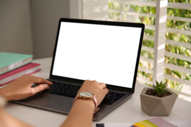 Woman working with modern laptop at white table, closeup. Space for design