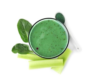 Photo of Glass of spirulina smoothie, powder, spinach and celery on white background, top view