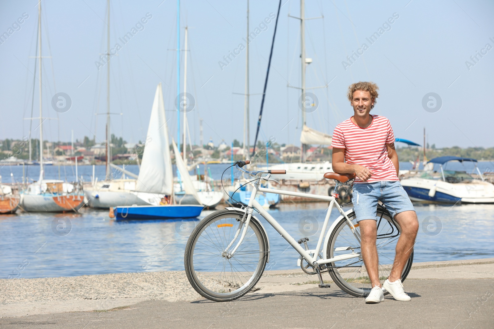 Photo of Handsome man with bicycle at pier on sunny day