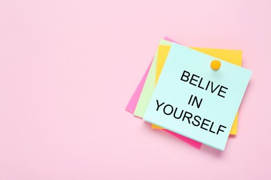 Photo of Notes with phrase Believe In Yourself and space for text on pale pink background, top view. Motivational quote