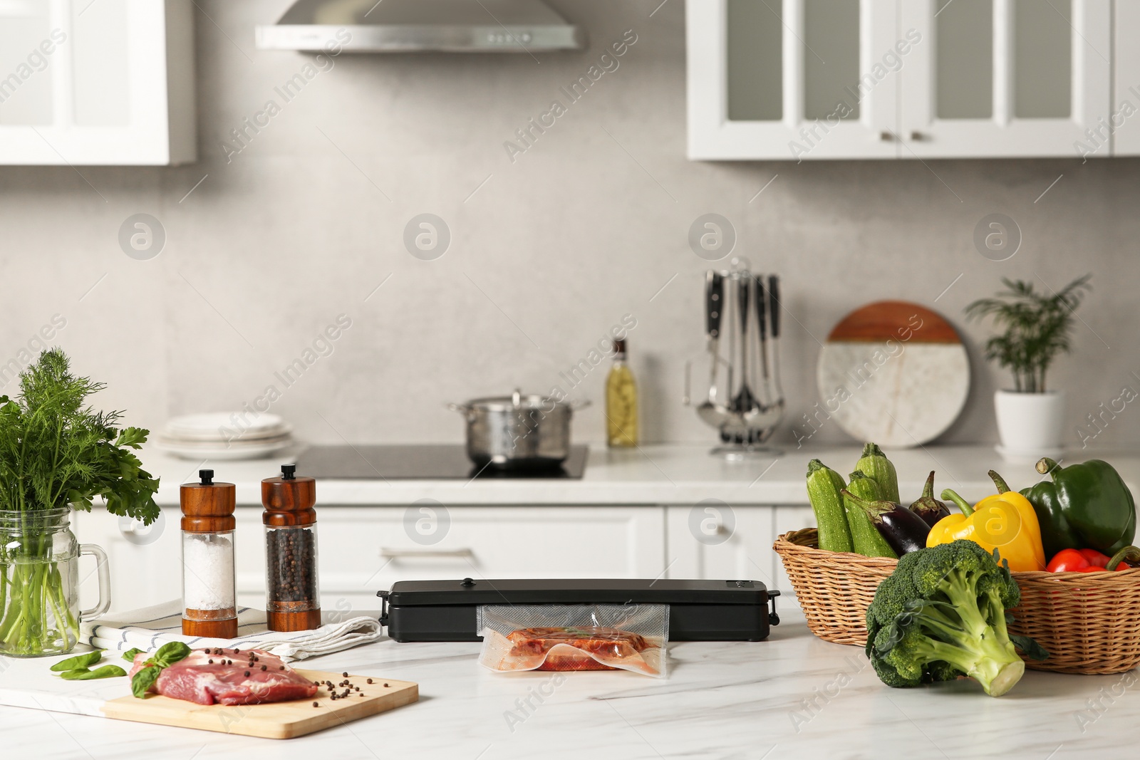 Photo of Sealer for vacuum packing with meat in plastic bag on white kitchen table