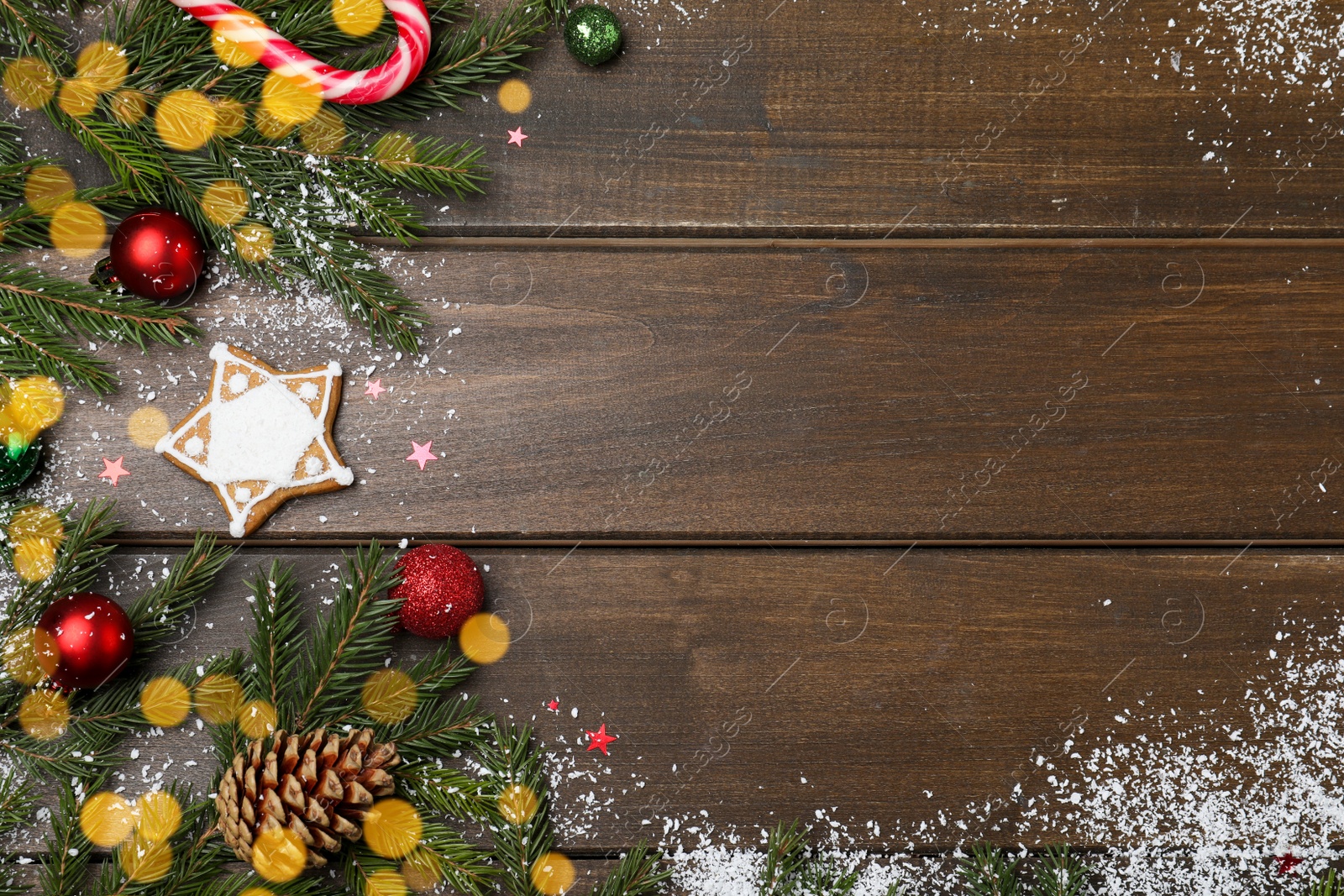 Photo of Christmas greeting card with space for text. Flat lay composition of fir tree branches and festive decor on wooden background