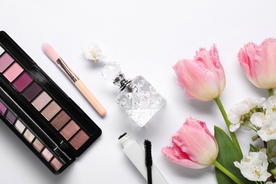 Photo of Flat lay composition with different makeup products and beautiful spring flowers on white background