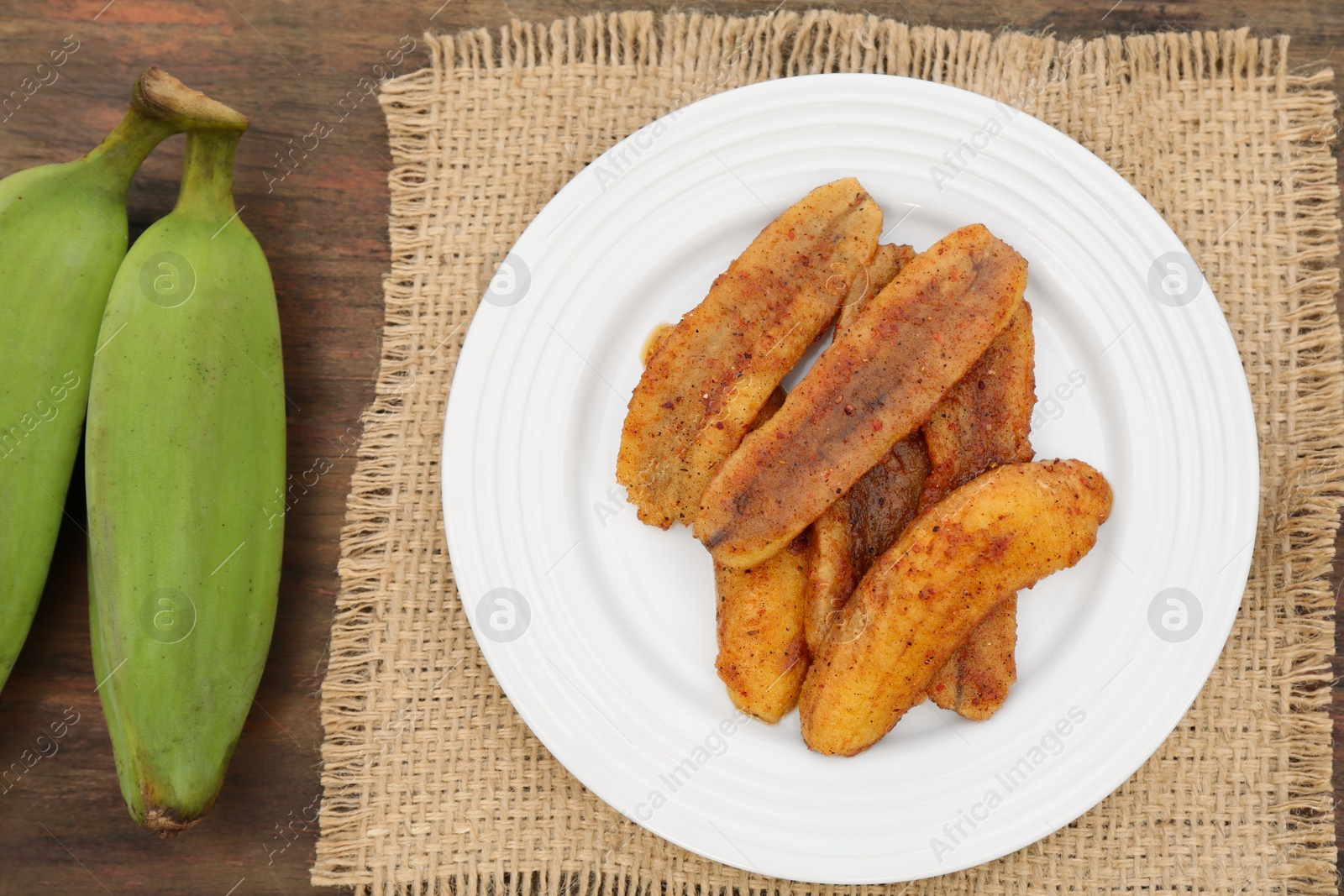 Photo of Delicious fried bananas and fresh fruits on wooden table, flat lay