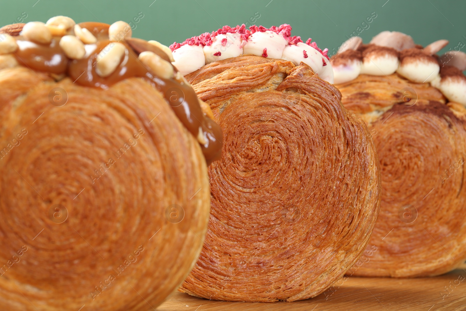 Photo of Crunchy round croissants on wooden board, closeup. Tasty puff pastry