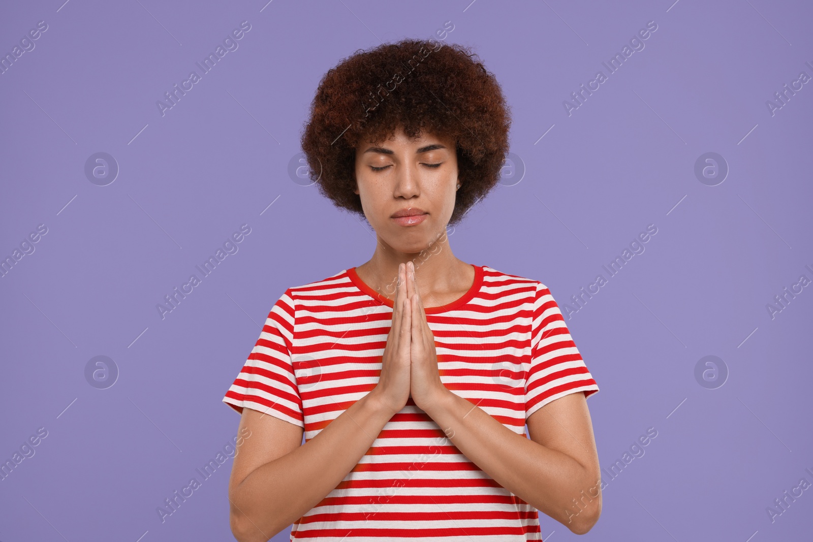 Photo of Woman with clasped hands praying to God on purple background