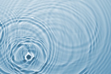 Image of Rippled surface of clear water on light blue background, top view