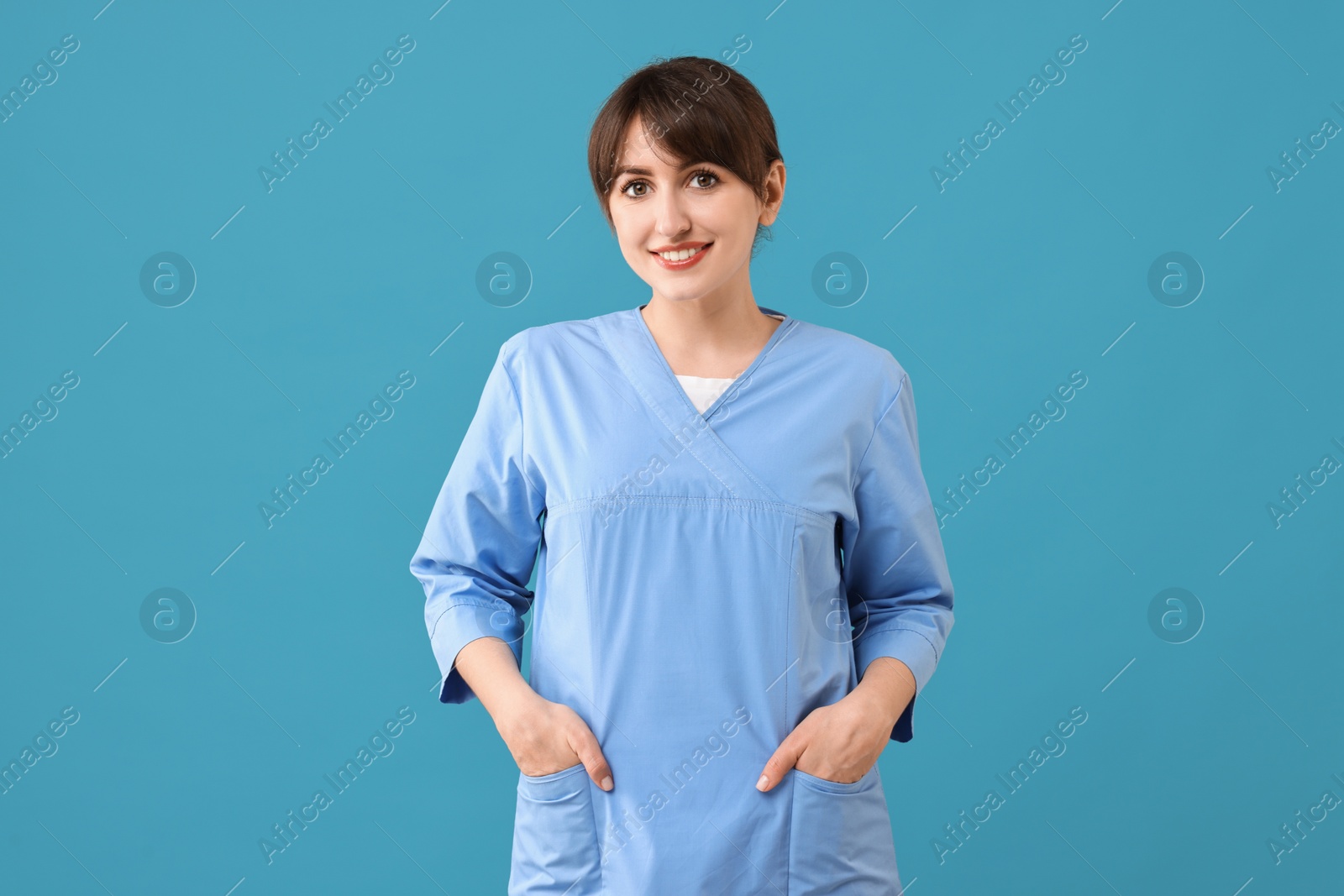 Photo of Portrait of smiling medical assistant on light blue background