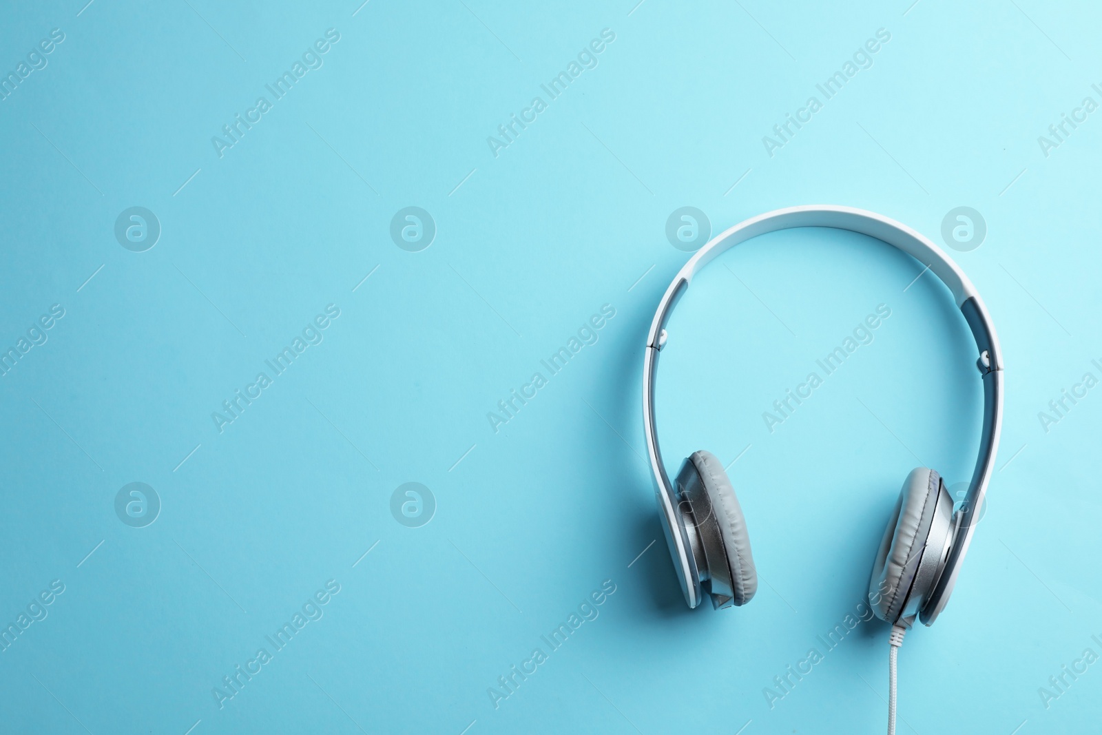 Photo of Stylish headphones on color background, top view. Space for text