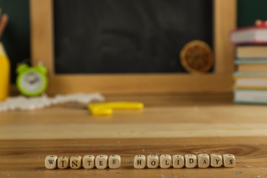 Photo of Wooden cubes with phrase Winter Holidays on table. Space for text