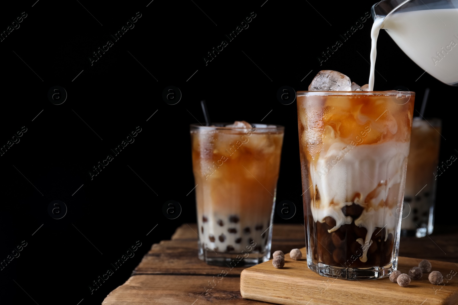 Photo of Making tasty milk bubble tea on wooden table. Space for text