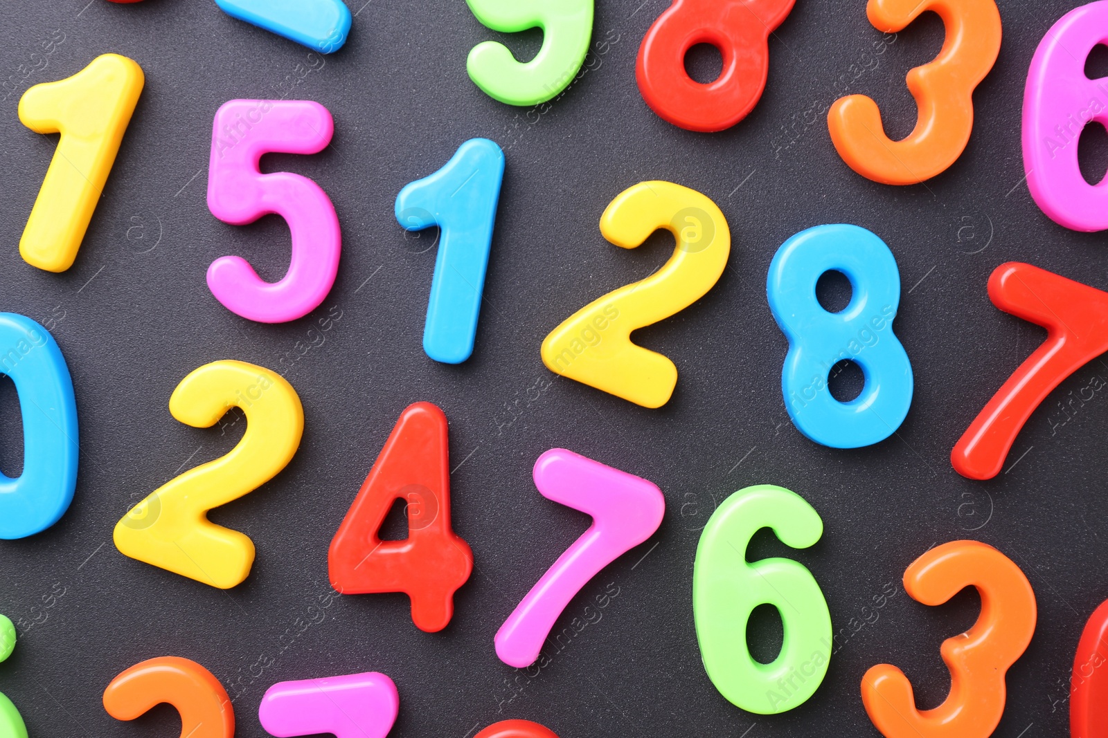 Photo of Colorful numbers on dark gray background, flat lay