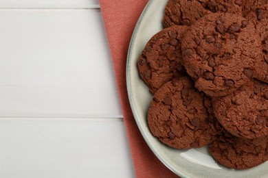 Delicious chocolate chip cookies on white wooden table, top view. Space for text