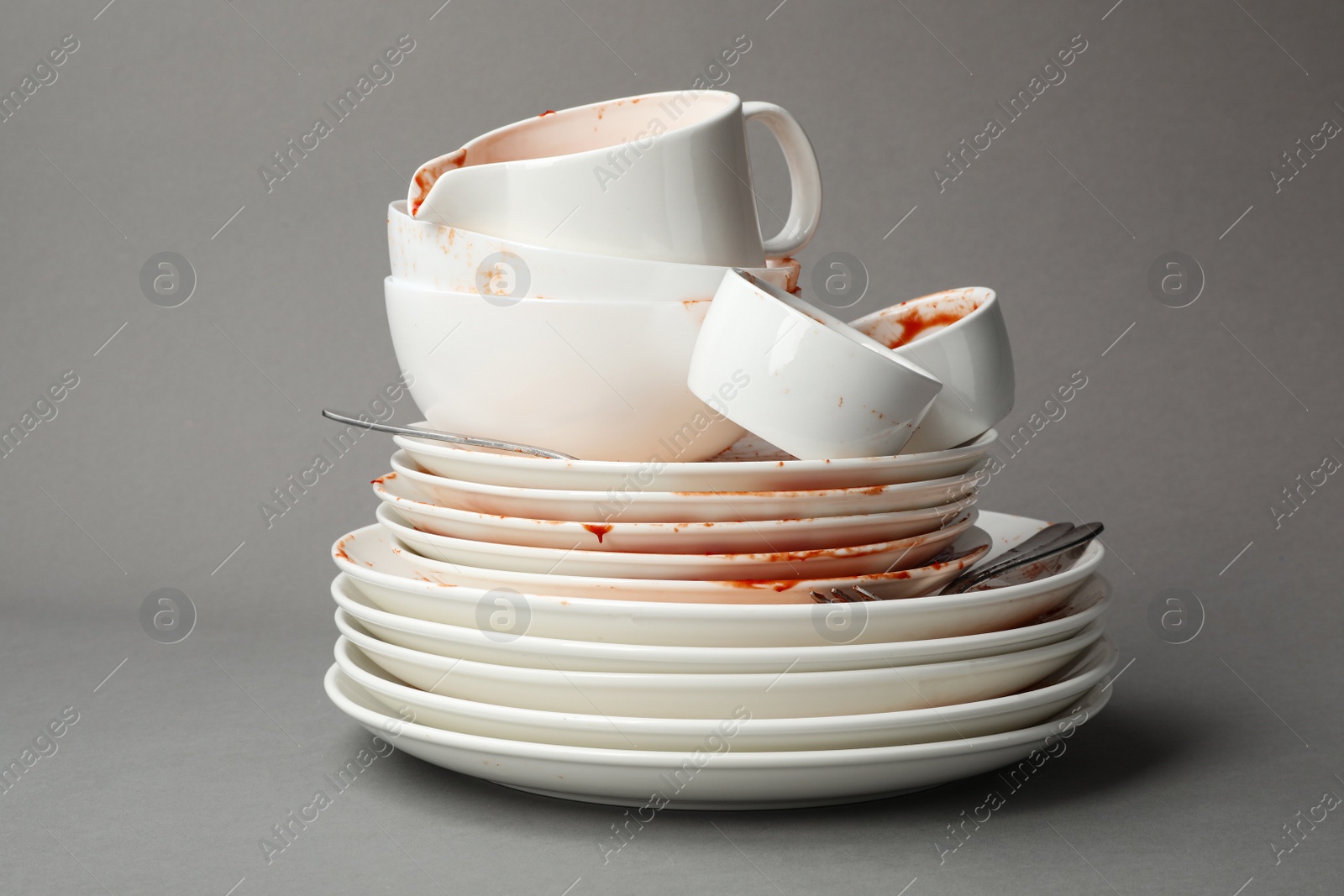 Photo of Set of dirty dishes on grey background