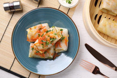 Photo of Delicious cabbage rolls served on white wooden table, flat lay