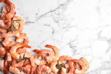 Photo of Tasty boiled shrimps with rosemary on marble table, flat lay. Space for text