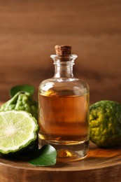 Photo of Glass bottle of bergamot essential oil on wooden table