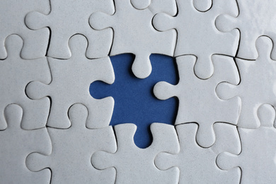 Photo of White puzzle with missing piece on blue background, top view. Career promotion concept