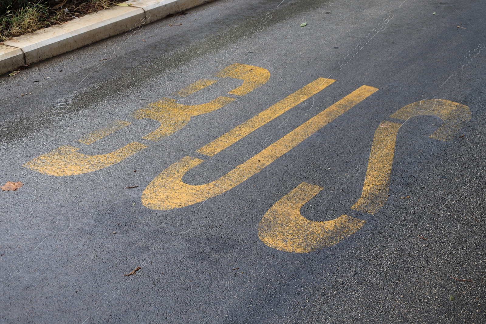 Photo of Empty bus stop pad on asphalt road