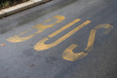 Photo of Empty bus stop pad on asphalt road