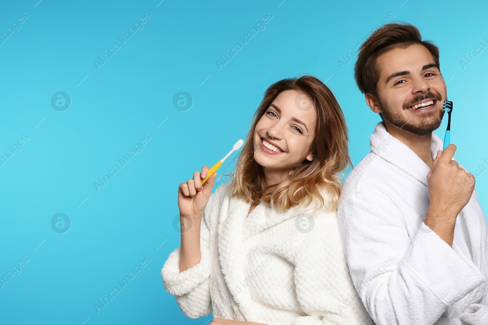 Photo of Portrait of young couple with toothbrushes on color background. Space for text