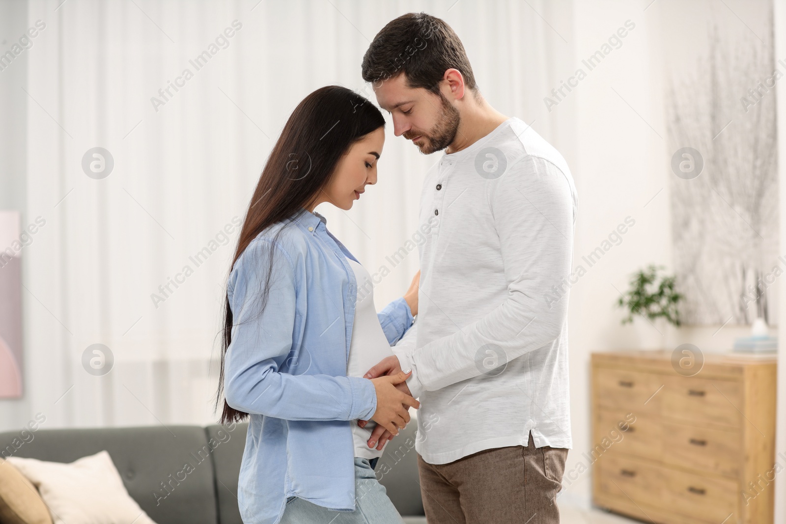 Photo of Pregnant young woman with her husband at home